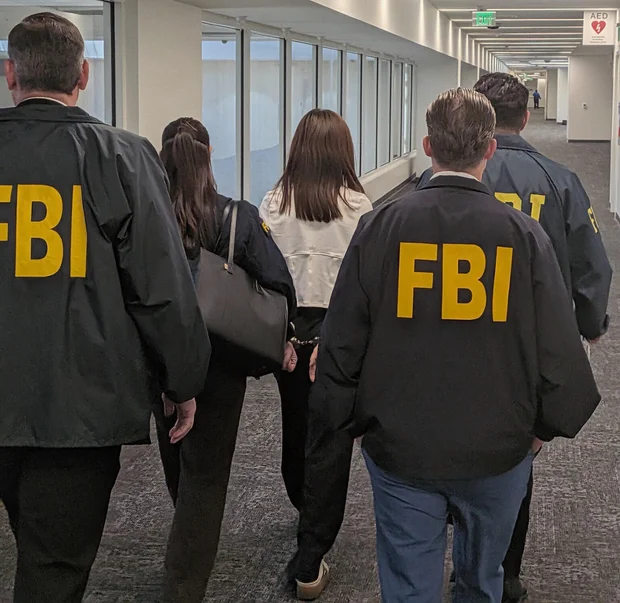 10月4日，FBI探员在洛杉矶国际机场押送被控未登记外国代理人的张婉莹。图片由美国司法部提供｜来源：U.S. Department of Justice via CBS News