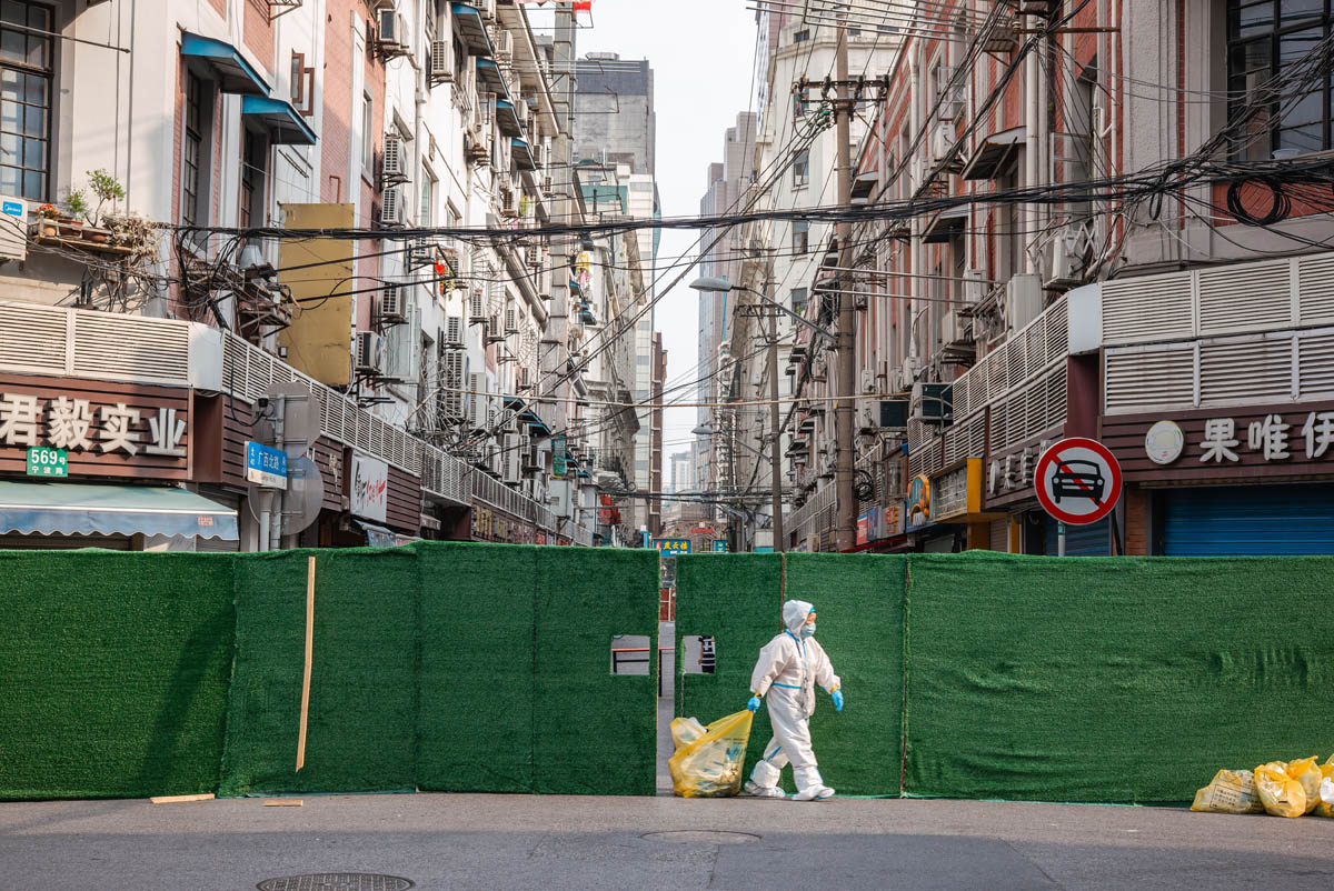 2022年4月上海封控期间,防护服人员行经封闭围挡的街道。资料照片|来源:Sixth Tone 第六声 / 原始新闻摄影版权保留